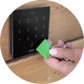 Hand hält NFC Keyfob an Loxone NFC Code Touch
