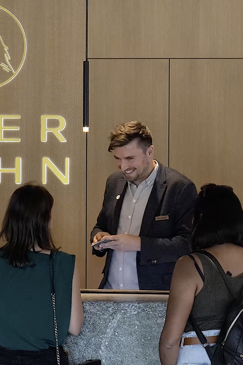 Hotelteam an der Theke profitiert von smarter Hotelautomation und mehr Zeit für die Gäste