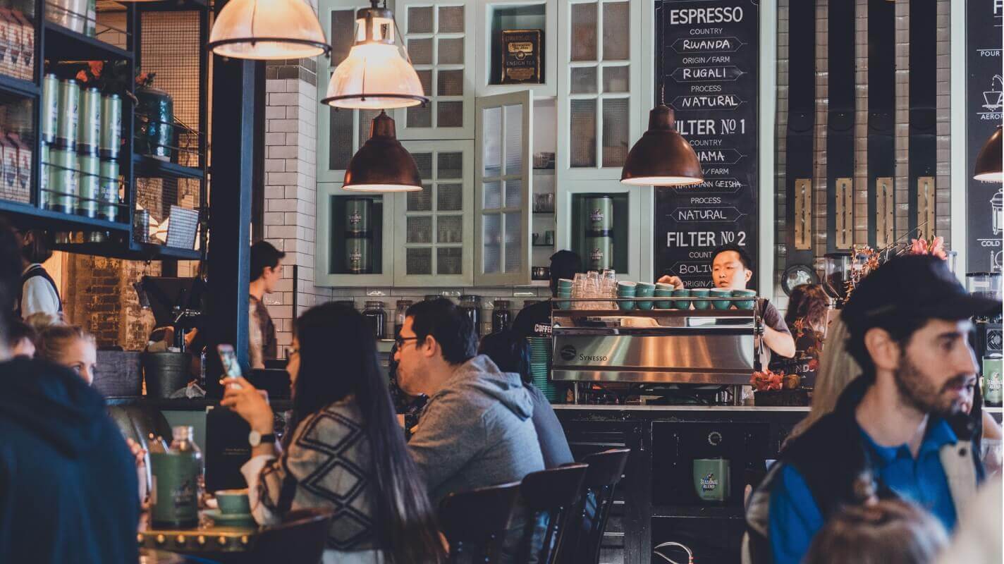 A cafe with many customers inside and multiple lights and other appliances on