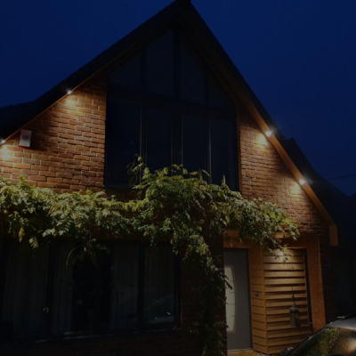 A family home with its lights on at night equipped with a Loxone BeMS installation