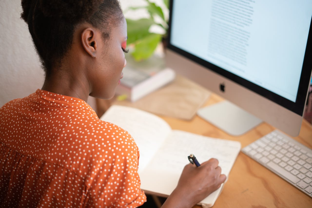 A woman working from home at her desk in front of a monitor