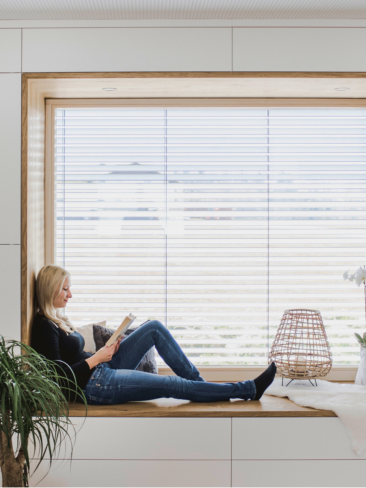 Woman lounging by the window in a well temperated room