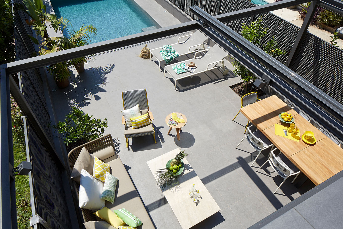 Sun Worshipper Smart Home Sunny outdoor patio area with a pool and loungechairs.