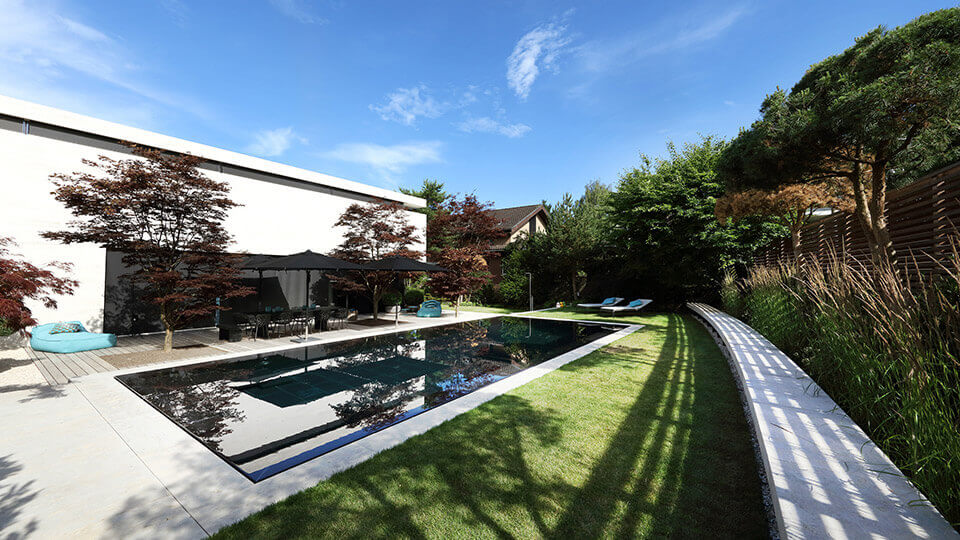 Wide-angle view of dark pool with shaded garden area