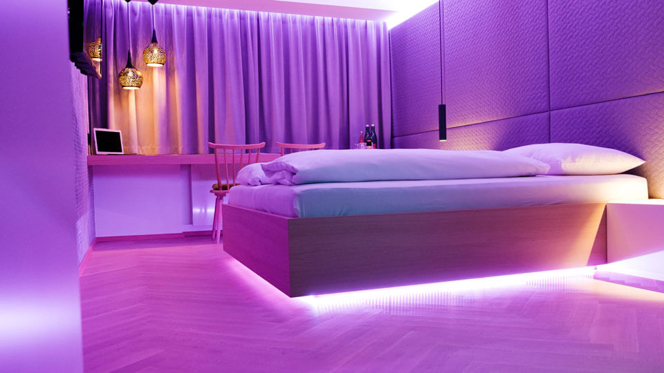 Hotel room with purple lighting under bed