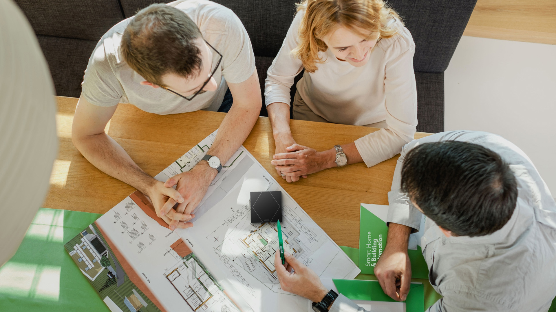 A picture showing a couple. The two are getting advice from a man regarding intelligent building automation.