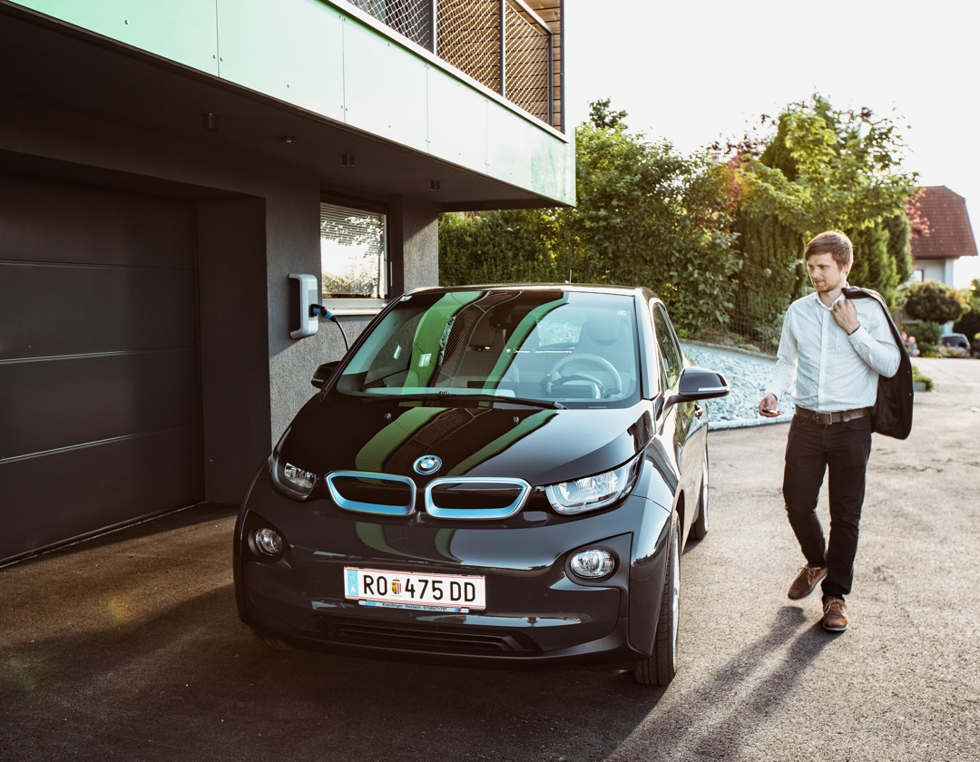 Homme qui entre dans une voiture électrique