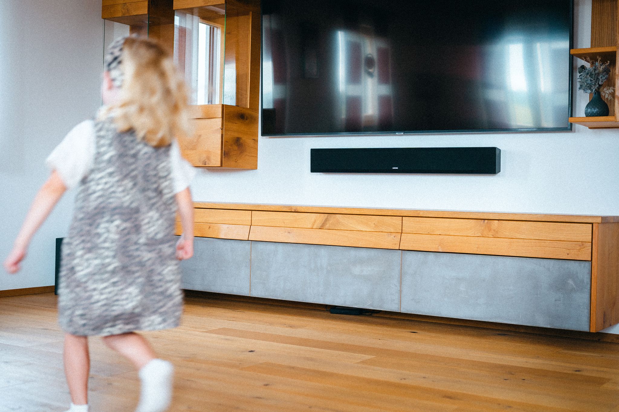 Child in a Living room with in front of a TV and LOXONE Soundbar