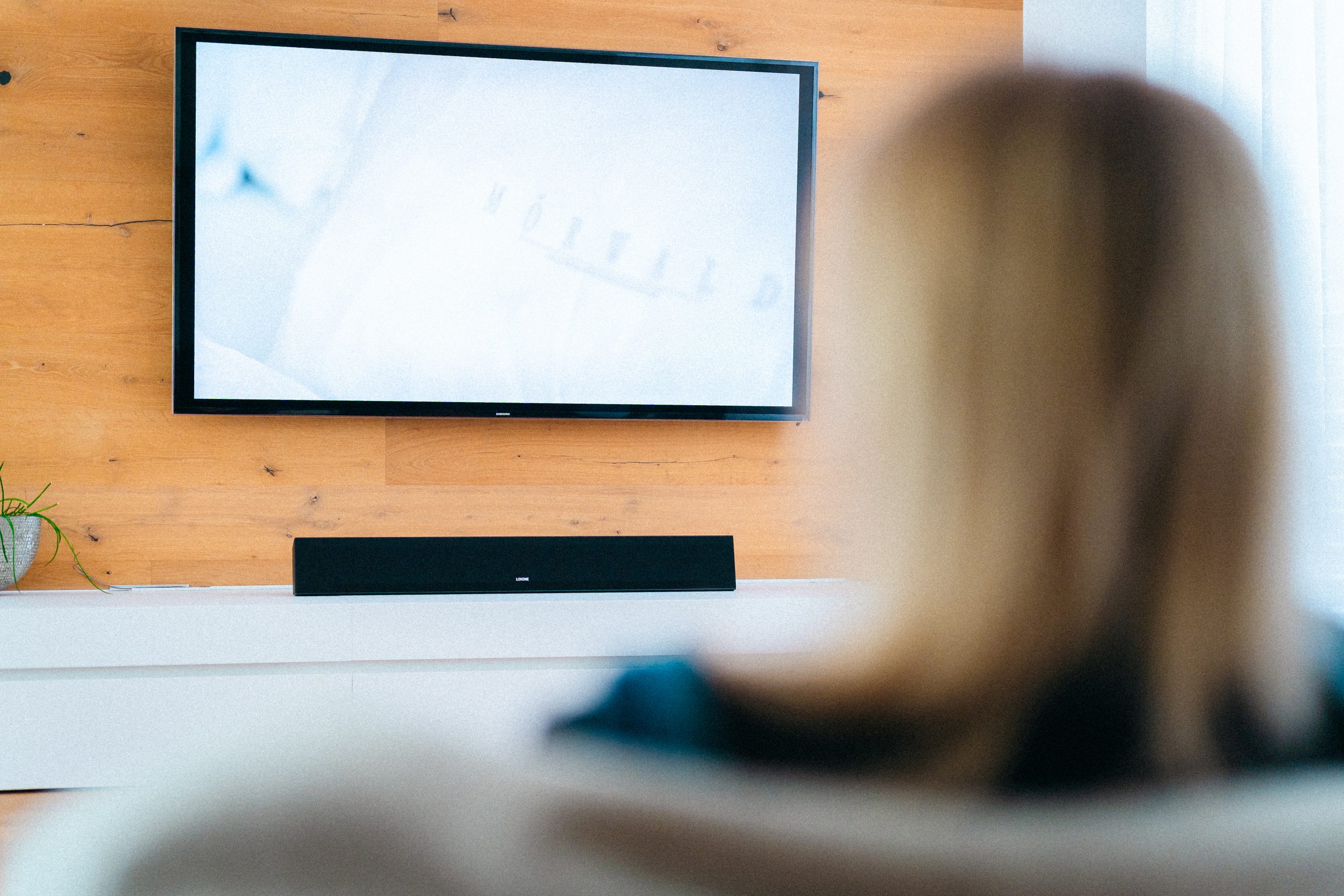 Child in a Living room with in front of a TV and LOXONE Soundbar