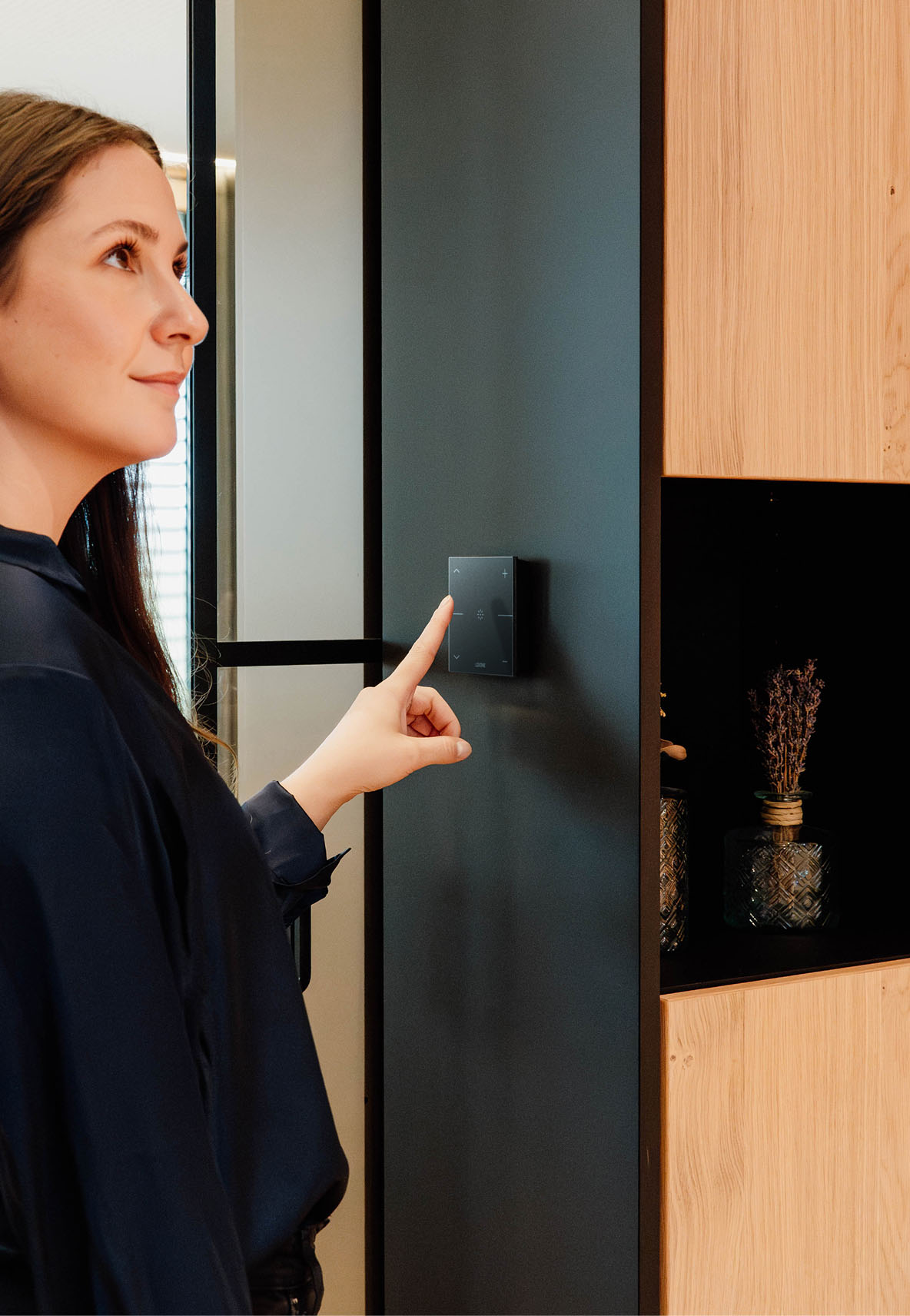 Hand operating a LOXONE Touch Pure switch on the wall