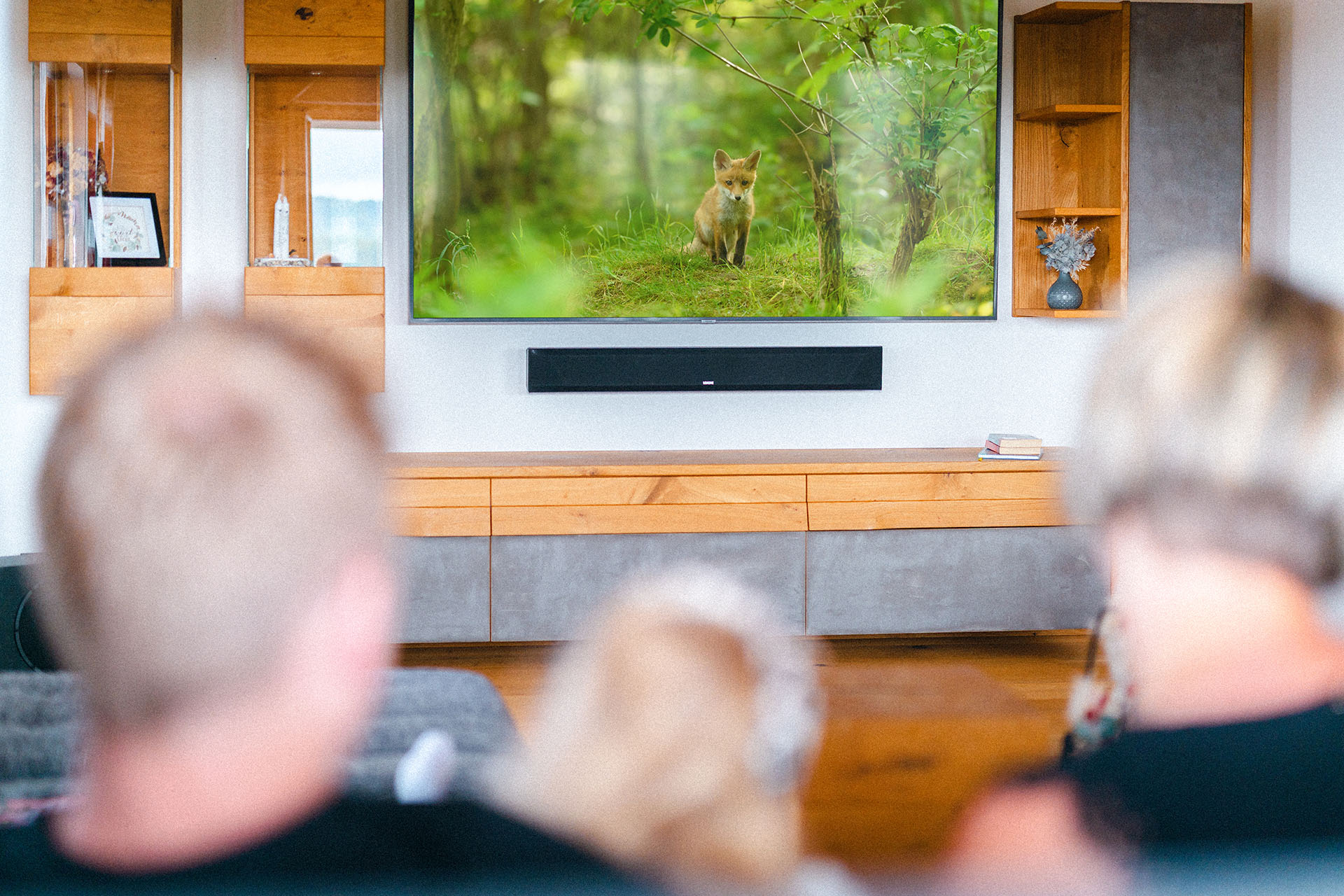Family movie night on the sofa, with the LOXONE Soundbar playing beneath the TV