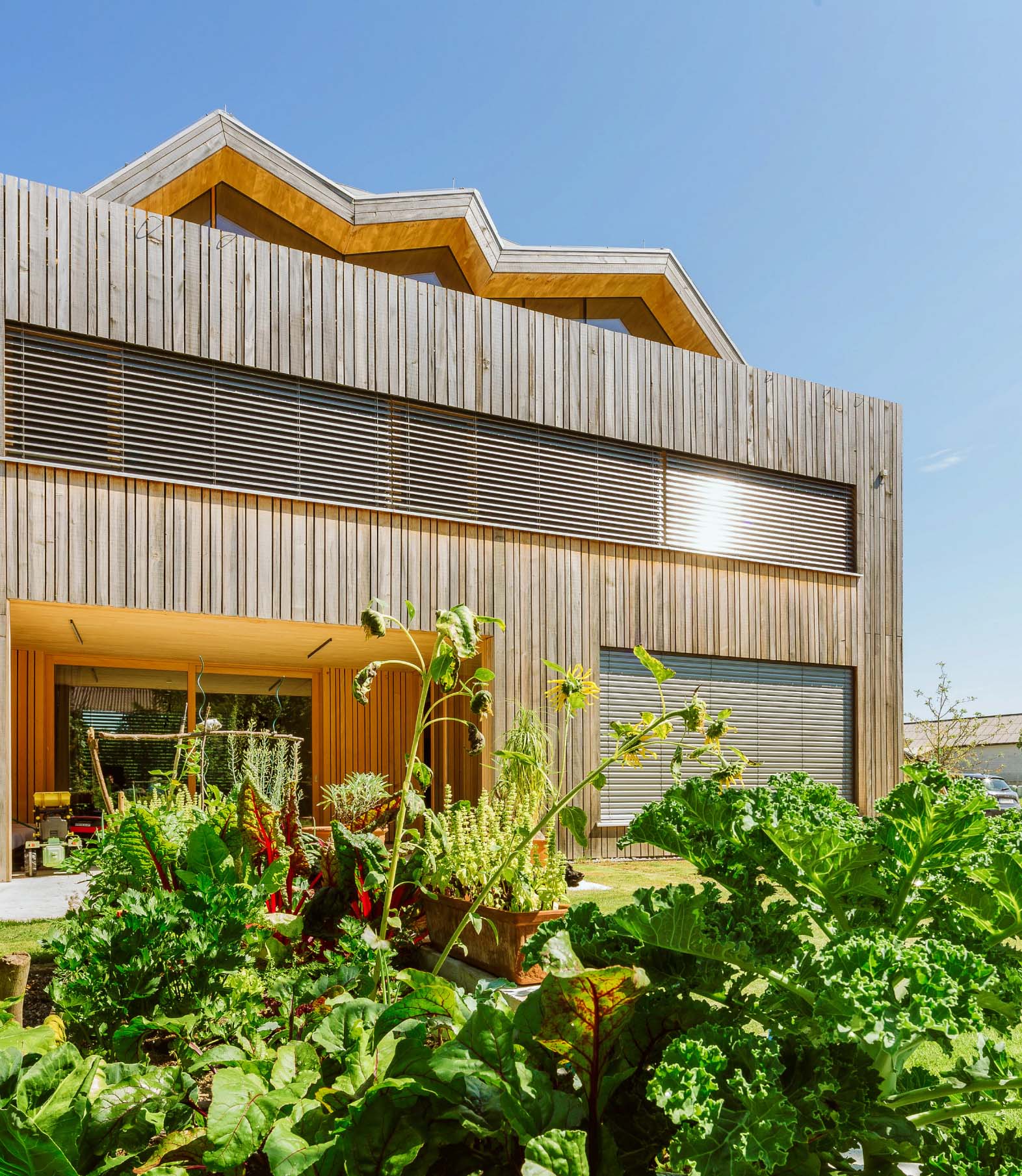 Außenansicht eines Smart Homes mit Garten mit geschlossenen, intelligent gesteuerten Raffstores.