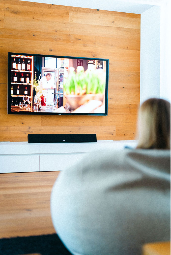 LOXONE Soundbar beneath a wall-mounted TV in a bright, modern living room