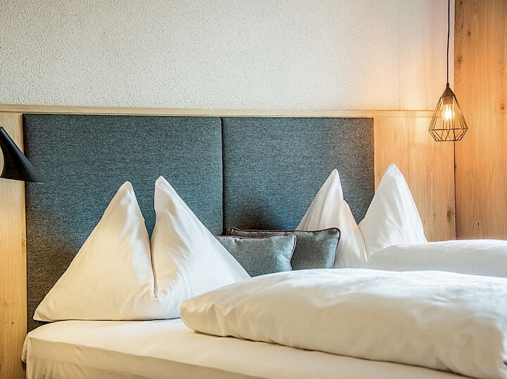 Pohľad na posteľ hotelovej izby v Alpenrose
