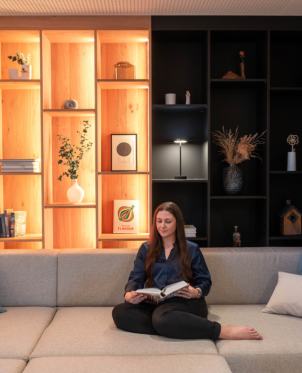 Žena v domácnosti číta knihu pri Table Lamp Air