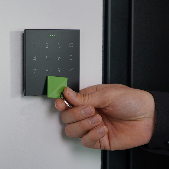 NFC-брелок прикладають до панелі NFC Code Touch для відчинення дверей розумного дому.
