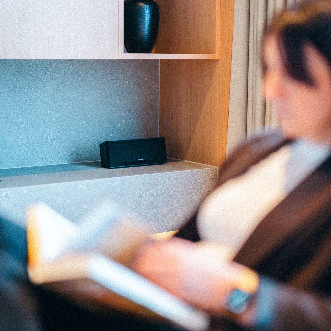 Дівчина читає книгу, в кімнаті лунає музика з Wireless Speaker.